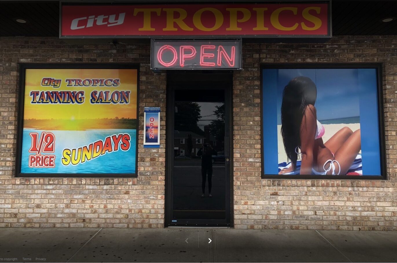 City Tropics Tanning salon storefront with illuminated sign and open neon
